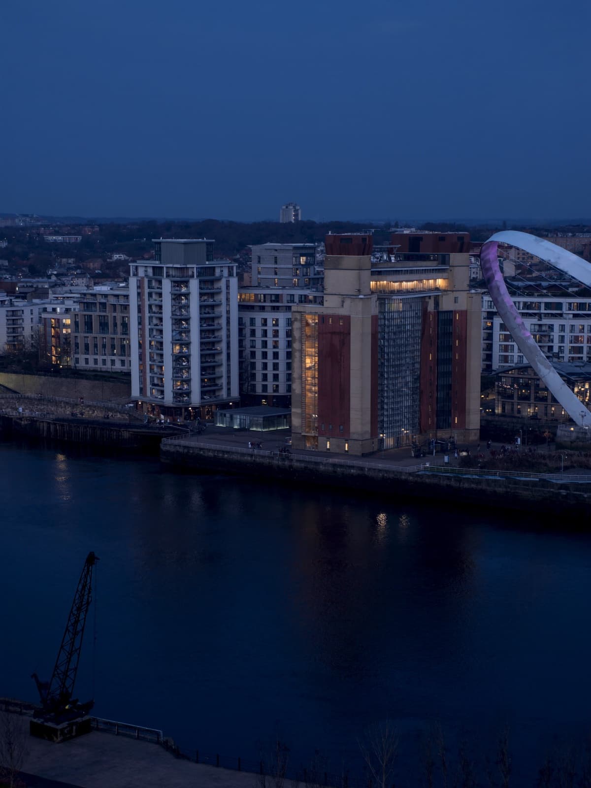 Riverside apartments and the Millennium Bridge on Newcastle Quayside at dusk