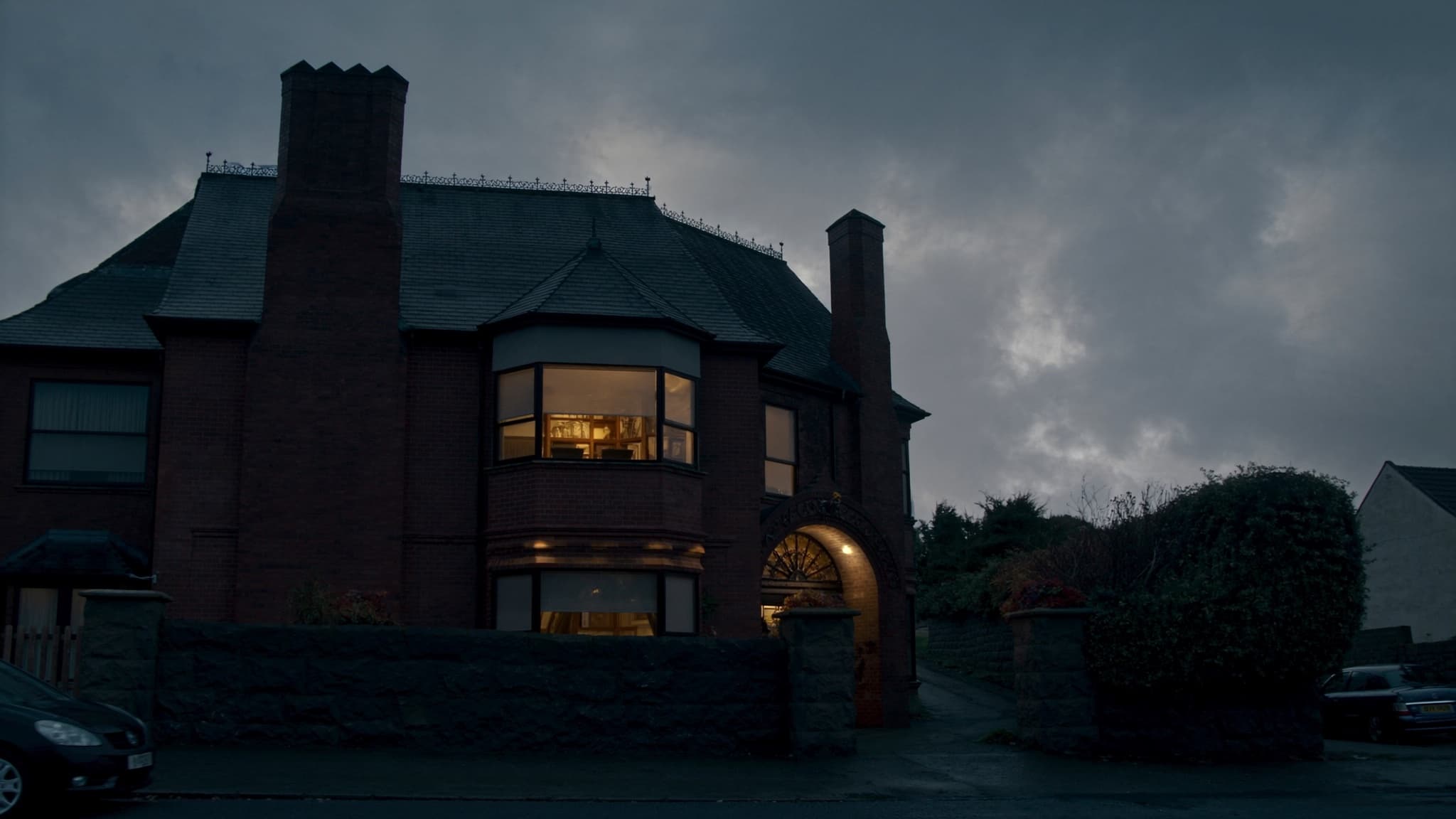 A red-brick Newcastle home glowing warmly at dusk after rain